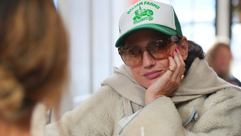 Jenna Lyons rocks oversized sunglasses and green trucker hat in the Hamptons