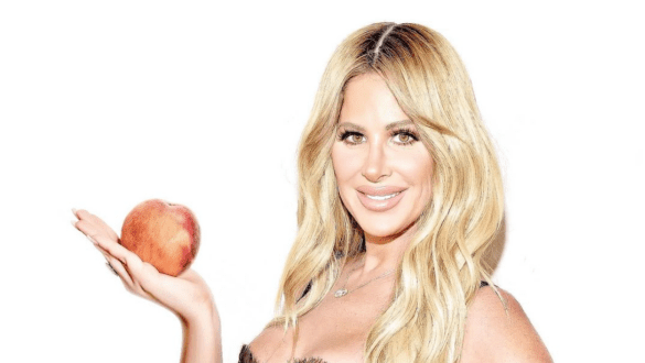 RHOA OG Kim Zolciak holds a peach